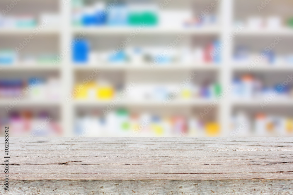 wood counter with blur shelves of drugs in the pharmacy