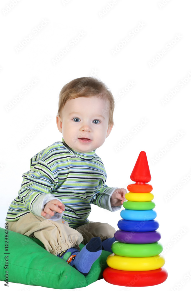 Caucasian baby boy playing colorful toys on a white background Caucasian baby boy playing colorful toys on a white background