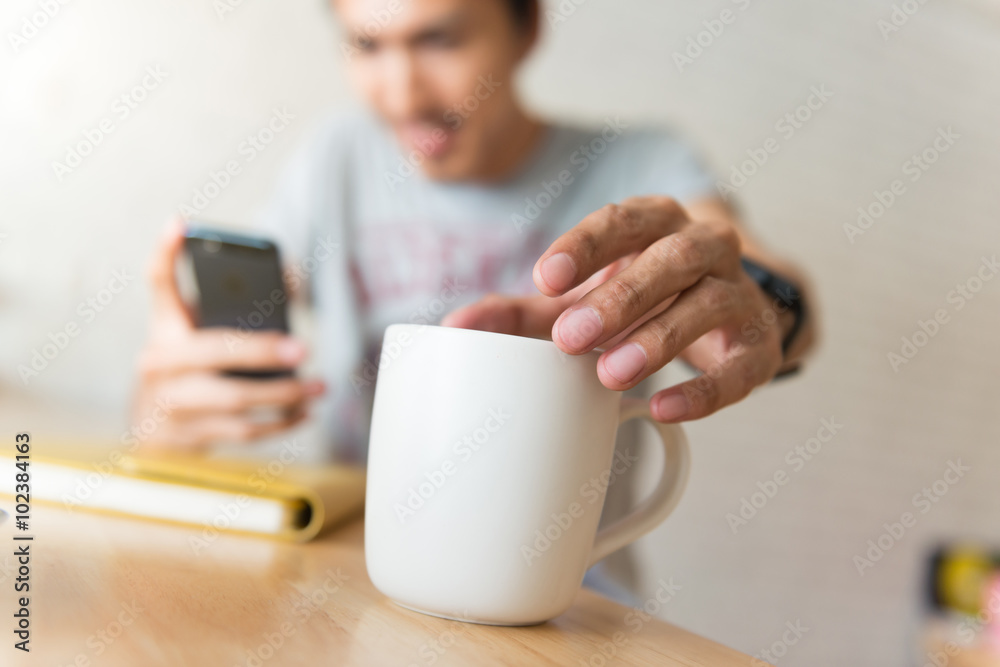 young man drinking coffee in cafe and looking at the phone screen young man drinking coffee in cafe and looking at the phone screen