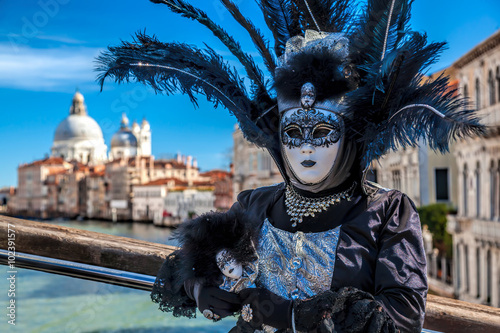 Beautiful carnival masks against Salute cathedral in Venice, Italy