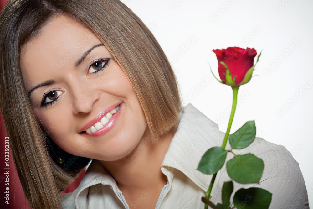 Close-up portrait of young beautiful woman with red rose