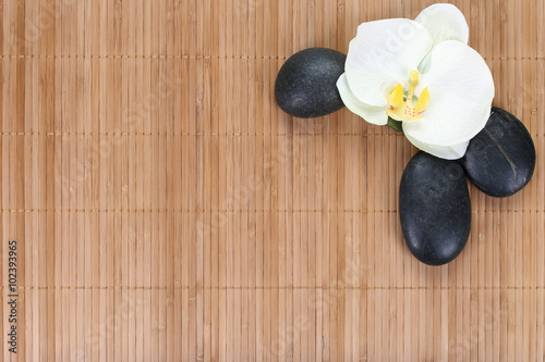 Orchid with zen stones on bamboo background