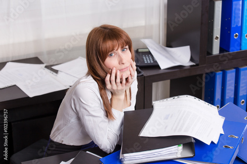 Overworked businesswoman with folders.