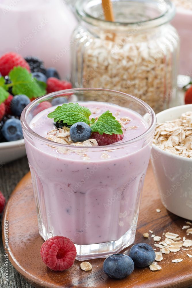 berry smoothie with oatmeal in a glass on wooden table, vertical berry smoothie with oatmeal in a glass on wooden table, vertical