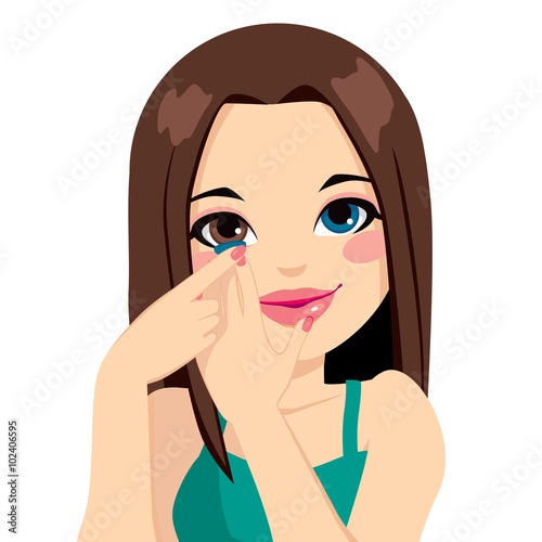 Beautiful brunette woman applying blue color cosmetic contact lenses on eyes