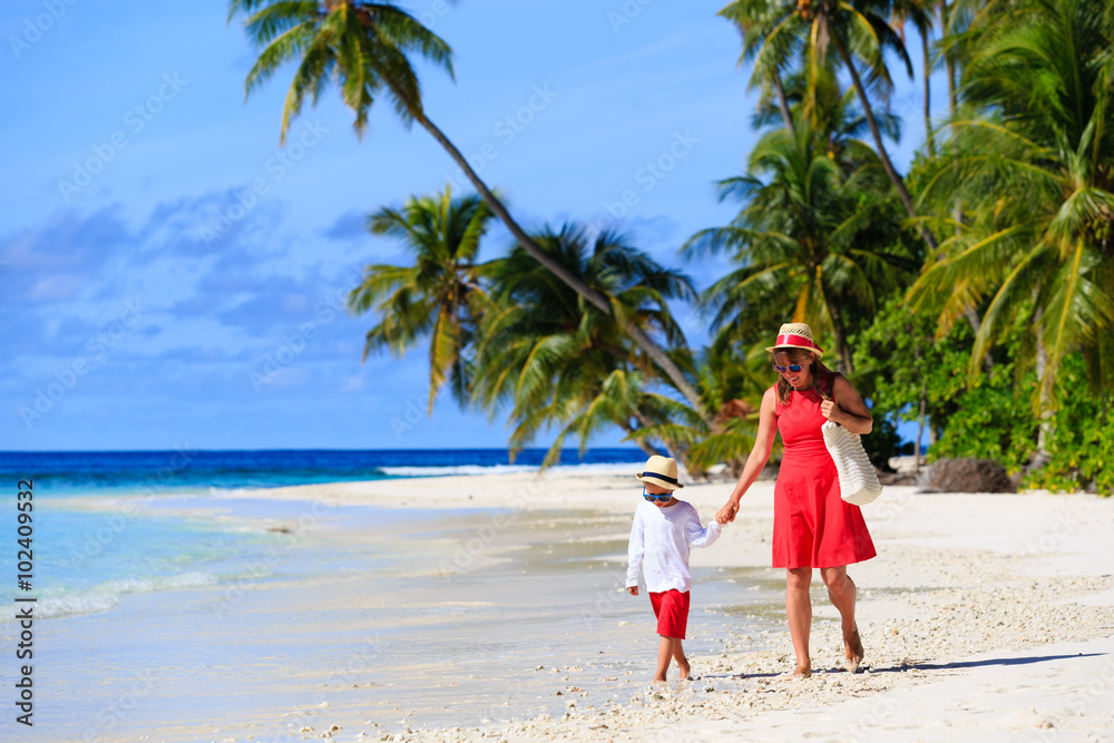 mother and son walk on summer beach