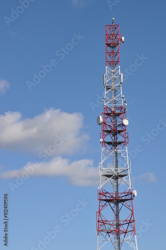 Telecommunication tower against cloudy sky