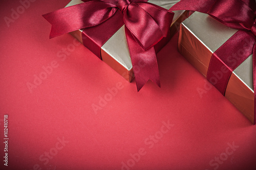 Present boxes on red background horizontal view holidays concept