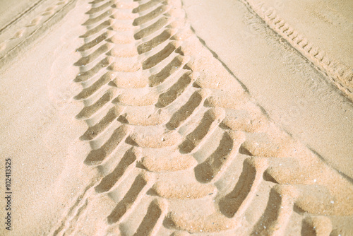 Wheel tracks on dry sand background
