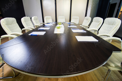 Top view of oval conference table with leather chairs