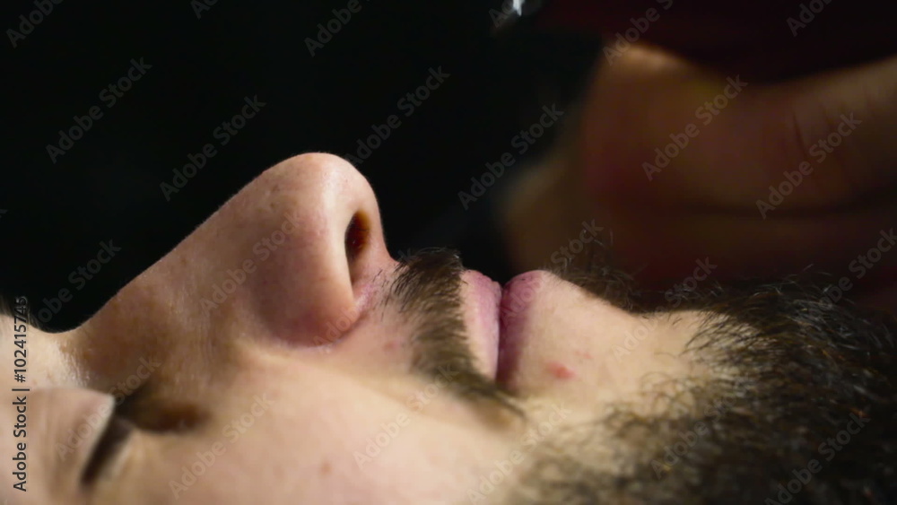 Barber shaves the beard of the client with trimmer slow motion close up Barber shaves the beard of the client with trimmer slow motion close up
