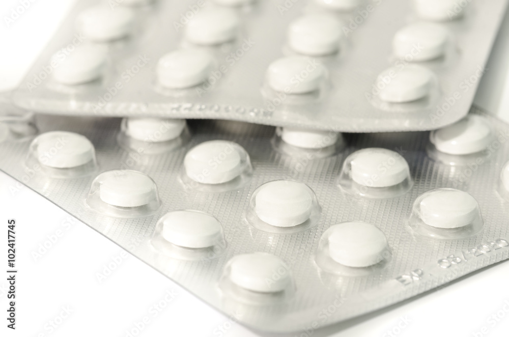 Small white pills in pack isolated on white Small white pills in pack isolated on white