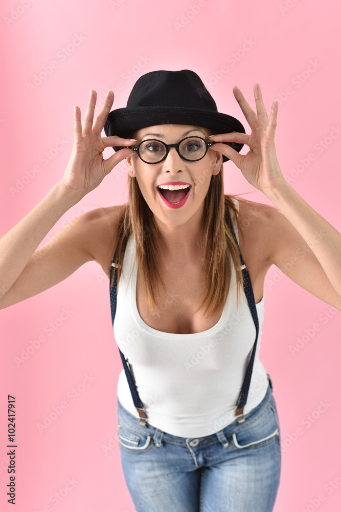 Fashion girl with hat and eyeglasses, isolated on pink background Fashion girl with hat and eyeglasses, isolated on pink background