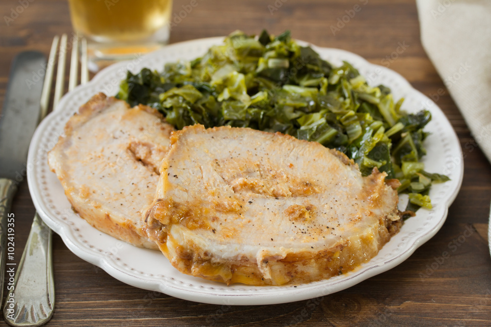 pork with cabbage on white plate on brown wooden background pork with cabbage on white plate on brown wooden background