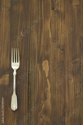 one fork on brown wooden background