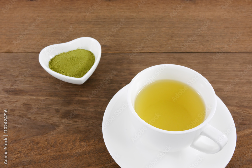 The cup of Japanese green tea on wooden planks. The cup of Japanese green tea on wooden planks.