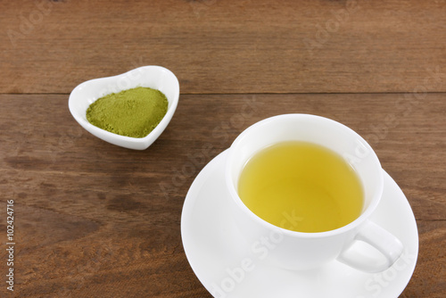 The cup of Japanese green tea on wooden planks.