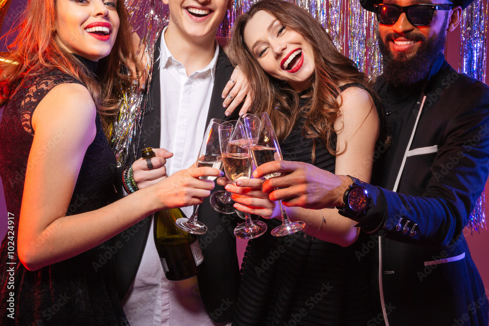 Fototapeta premium Group of cheerful young friends drinking champagne together