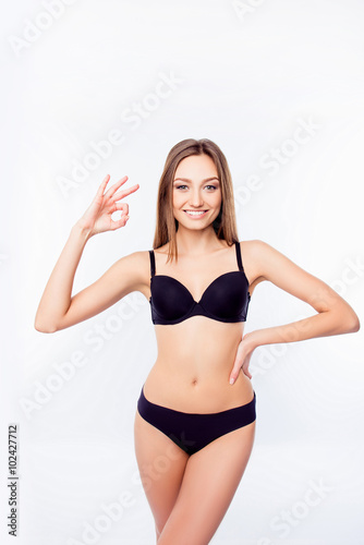 Young sexy woman in black undies gesturing OK