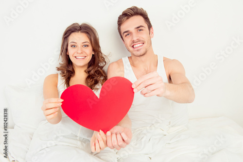 Lovely couple in love holding red paper heart