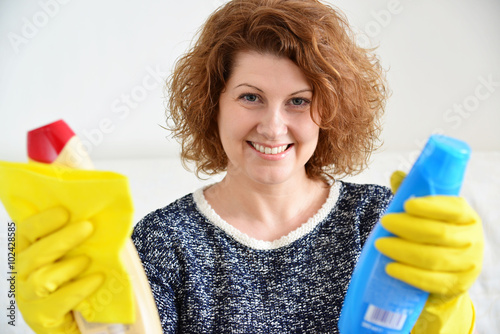 Foto happy woman in rubber gloves with cleaning agents