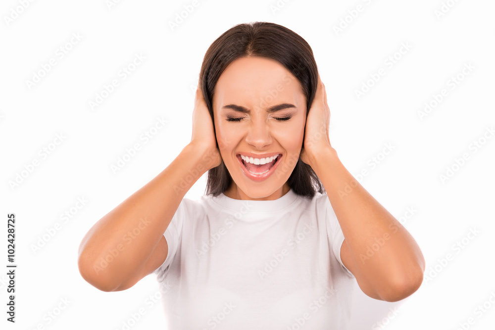 Close up photo of annoyed young woman plugging ears with hands Close up photo of annoyed young woman plugging ears with hands