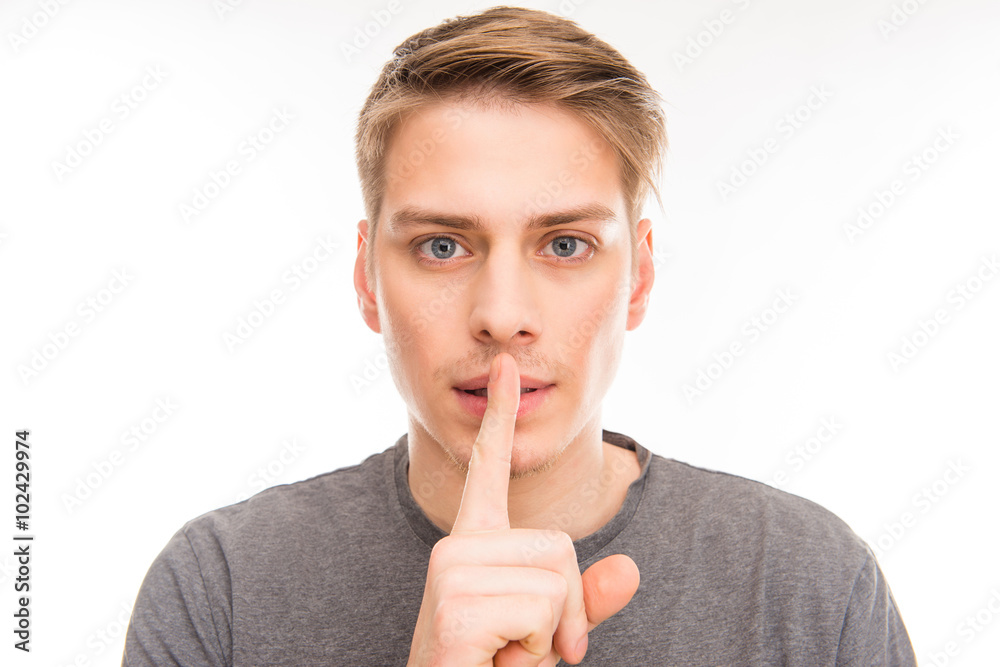 Attrative young man gesturing to make silence Attrative young man gesturing to make silence