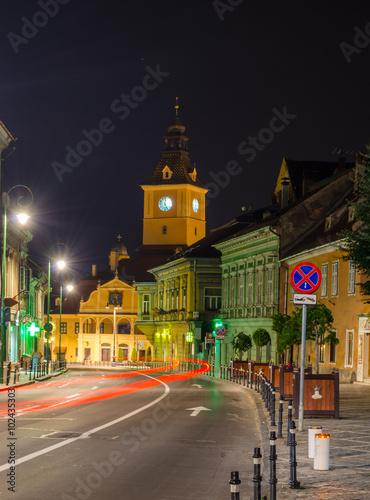 night view of the illuminated street of George Baritiu with a shining tower of the town hall in romanian city brasov. photo