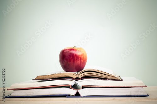apple on stack of open books