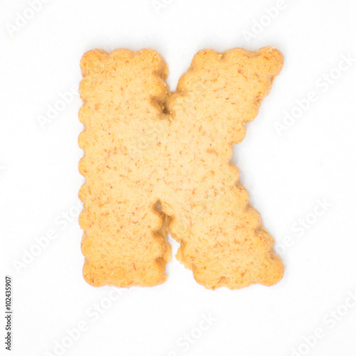 letter K made of cracker cookie isolated on white background.