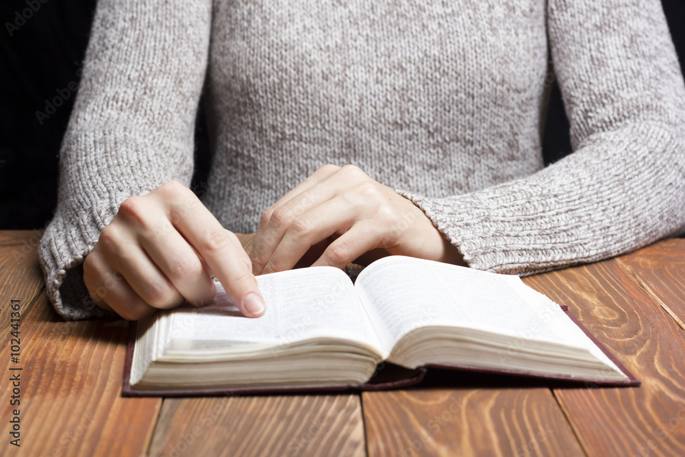 Closeup woman hand holding pocket book to read Closeup woman hand holding pocket book to read