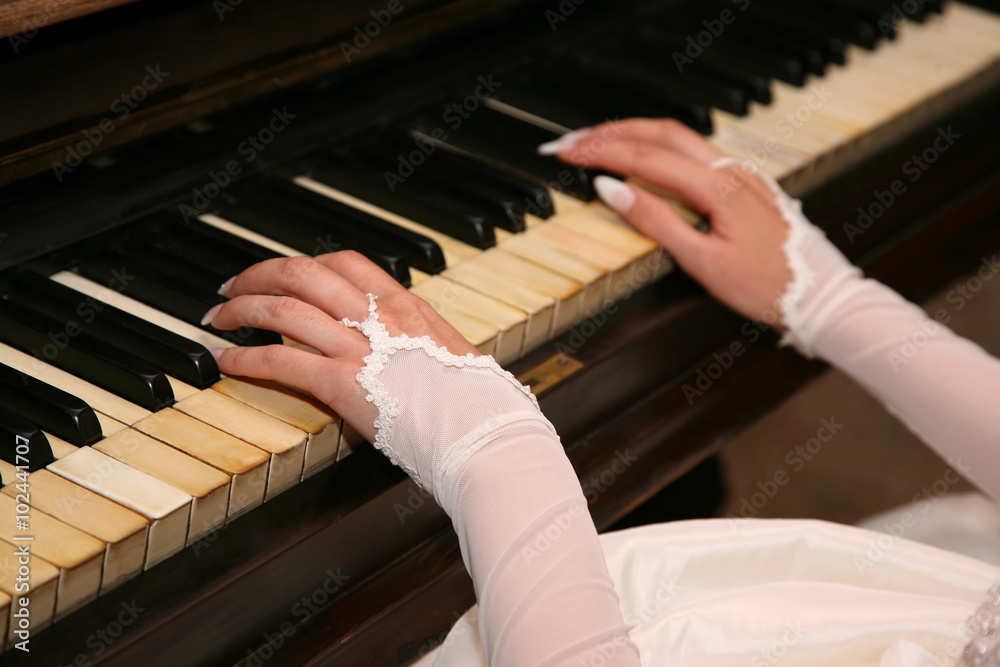 the bride plays the piano closeup