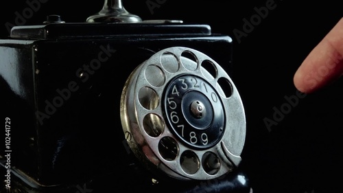 Old vintage telephone. 
Closeup on finger plate. Person is dialing a number. Sound included.