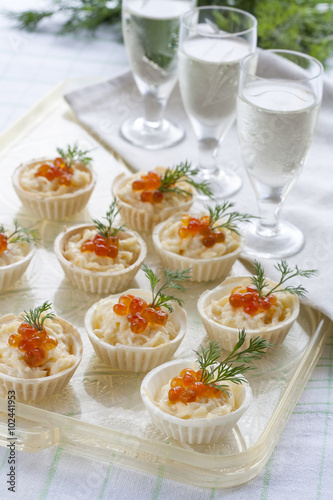 Tartlets with cream cheese and red caviar close up. Snacks with red caviar with aperitif. Light background.