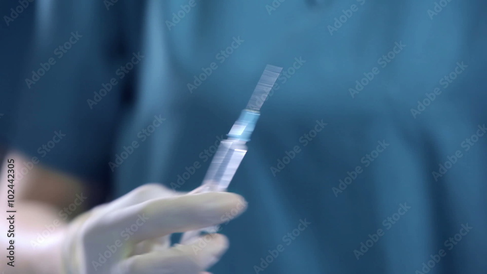Doctor gains a medicine into a syringe Doctor gains a medicine into a syringe