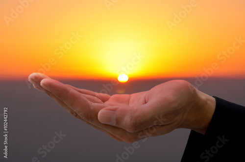 Hand under sunset