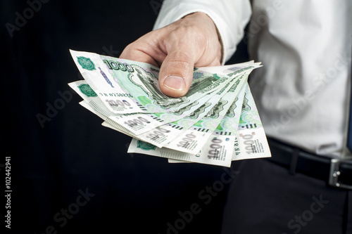Businessman holding a wad of money, russian rubles banknotes. Financial theme. Horizontal view.