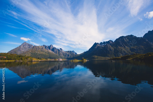 Classic norwegian scandinavian summer landscape with mountains, fjord, lake and a church, with a blue sky, Norway, Lofoten Islands