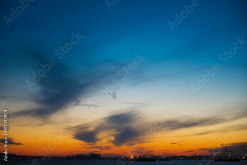 From the sea silhouette of New Jersey port with fire sunset