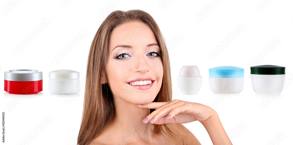 Beautiful young woman with gentle makeup and cosmetic bottles isolated on white Beautiful young woman with gentle makeup and cosmetic bottles isolated on white