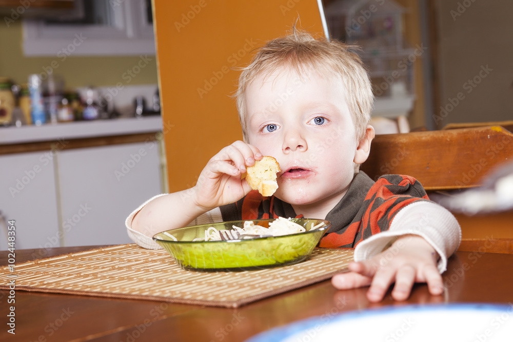 little boy two years eating pasta indoor. Toddler child in domestic kitchen little boy two years eating pasta indoor. Toddler child in domestic kitchen