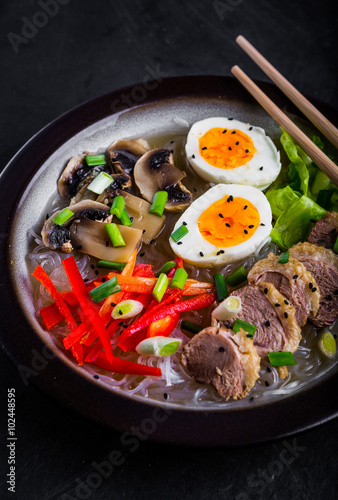Noodles with egg and duck meat in bowl