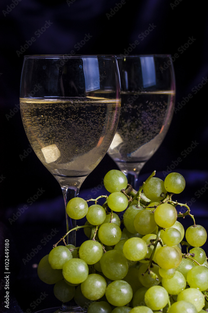 Glasses of wine and grapes on a dark background Glasses of wine and grapes on a dark background