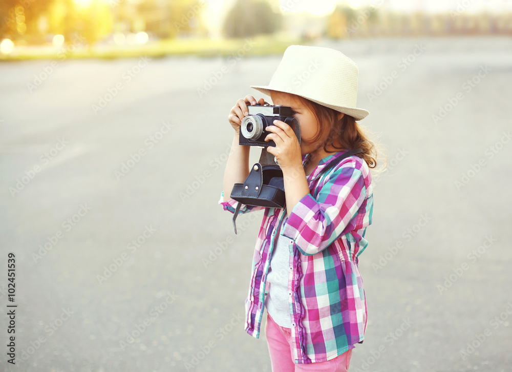 Little girl child with retro camera doing snapshot outdoors, pro Little girl child with retro camera doing snapshot outdoors, pro