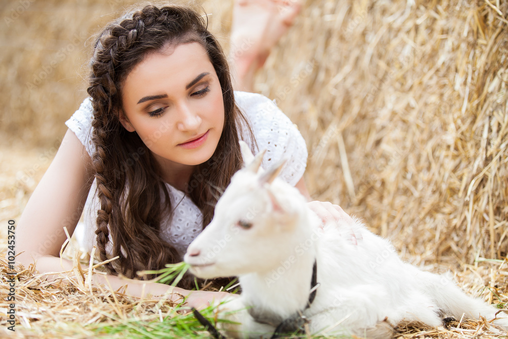 Young woman hugging a small lamb at farm Young woman hugging a small lamb at farm