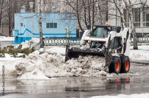 loader removes snow on city streets