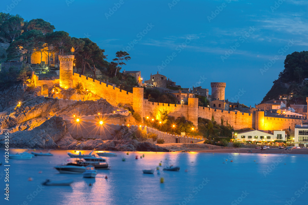 Night view of fortress and fishing boats in Tossa de Mar on Costa Brava, Catalunya, Spain