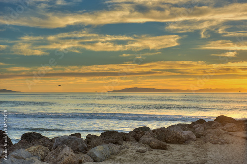 Ventura beach golden sunset over the rolling surf.
