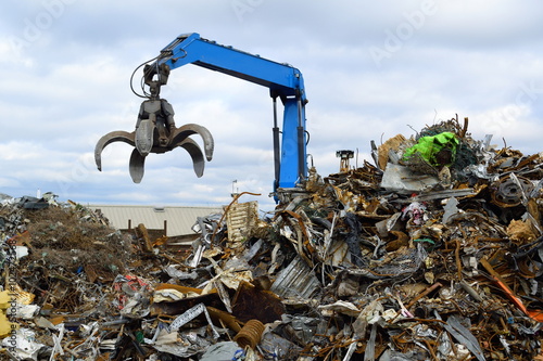 Blue hydraulic Clow Crane used for picking up scrap metal at recycling yard photo