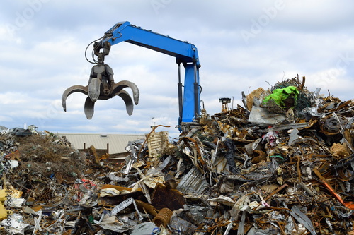 Blue hydraulic Clow Crane used for picking up scrap metal at recycling yard